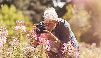 enjoying outdoors_senior man with camera-400x229